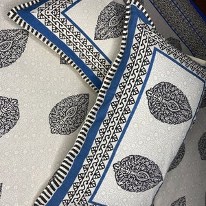 May include: Two white pillowcases with blue and black paisley patterns. The pillowcases have a white background with a blue and black border.