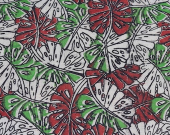 May include: A white fabric with a repeating pattern of green and red leaves. The leaves are stylized and have a black outline.