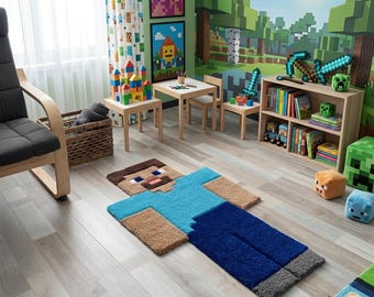 May include: A rectangular area rug shaped like a pixelated character with a brown head, light blue torso, dark blue legs, and gray feet. The rug features a blocky, geometric design with a textured surface, lying flat on a light wood floor.