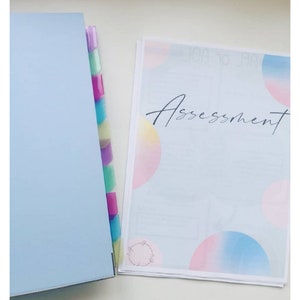 May include: A blue binder with colorful dividers and a white sheet of paper with the word "Assessment" written in black cursive. The paper has a pastel pink, yellow, and blue gradient design with circles.
