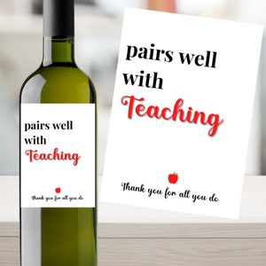 May include: A white wine bottle with a label that says "pairs well with Teaching" and a red apple graphic. The label also says "Thank you for all you do".