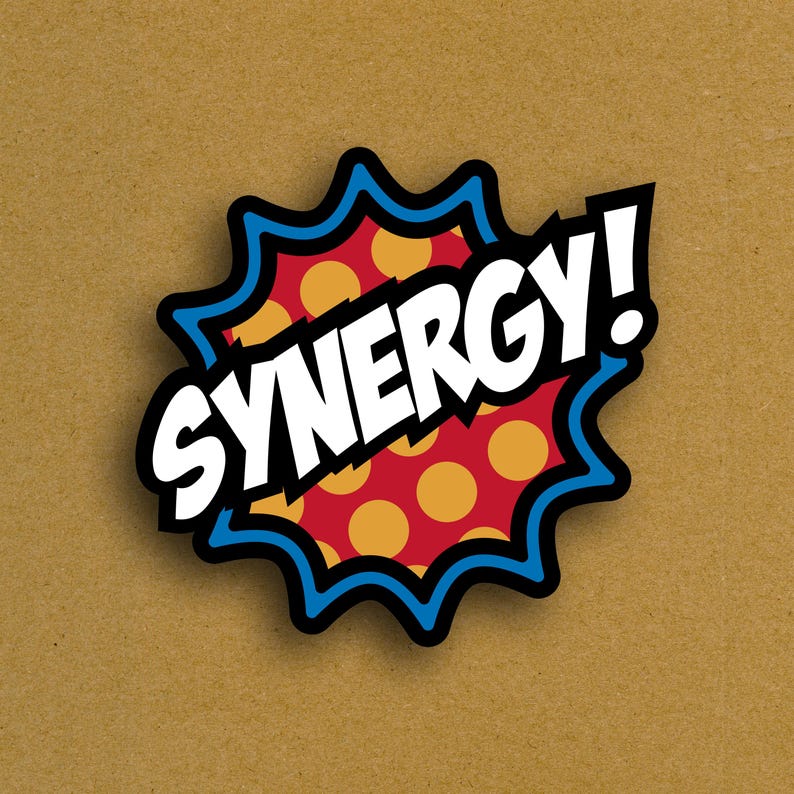 May include: A sticker with the word "SYNERGY!" in bold white letters. The sticker has a red background with yellow polka dots, a black outline, and a blue jagged border. The background is a light brown color.