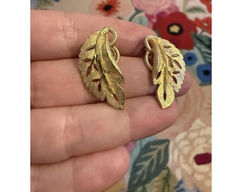 Pendientes de clip con forma de hoja en tono dorado estilo vintage de BSK, bisutería texturizada de mediados de siglo.