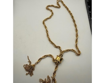 Collar tipo lariat vintage en tono dorado con borla, cadena de cuerda retorcida y cierre ajustable.