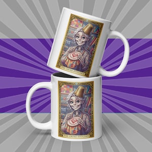 May include: Two white ceramic mugs with a whimsical illustration of a skeleton cross-stitcher. The illustration is framed in gold and features the text "THE CROSS-STITCHER". The mugs are set against a purple and gray background.