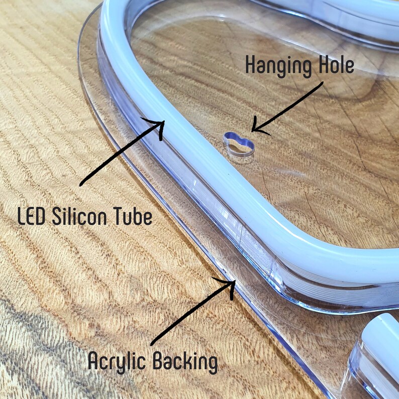 May include: Close-up of a clear acrylic sign with a white LED silicone tube. The sign has a hanging hole and the text "Hanging Hole" is written on the sign.