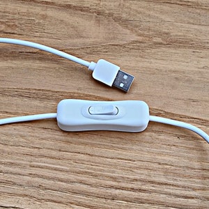 May include: A white USB cable with a white inline on/off switch. The cable is connected to a USB plug.