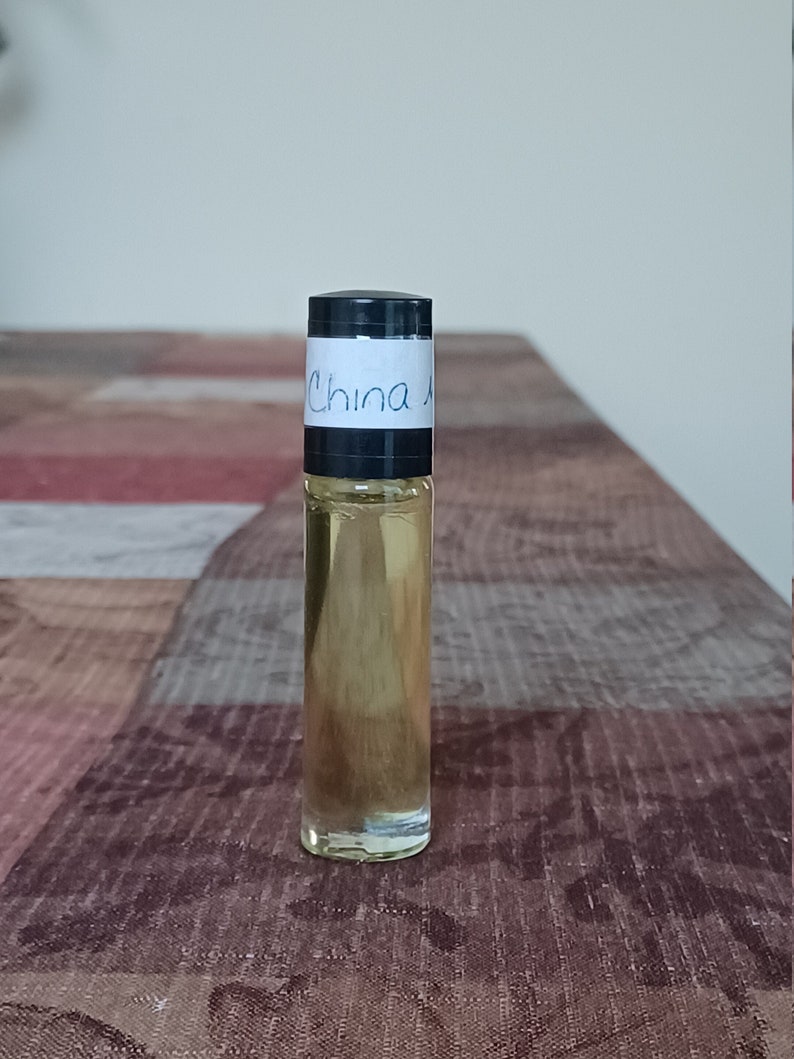 Może przedstawiać: Przezroczysta butelka szklana z czarną zakrętką i białą etykietą z napisem "China". Butelka jest wypełniona jasnoż&oacute;łtym płynem.