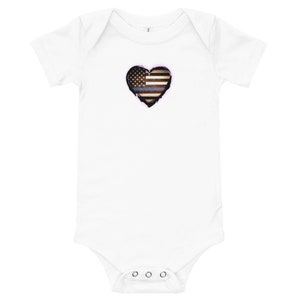 Peut inclure: Combinaison blanche pour bébé avec un drapeau américain bleu et blanc en forme de cœur avec une fine ligne bleue.