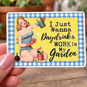 May include: A rectangular sticker with a blue and white gingham border, featuring a yellow background with white polka dots. It depicts a blonde figure in a blue gingham swimsuit holding a watering can and glass, with the text I Just Wanna Daydrink & WORK In My Garden.