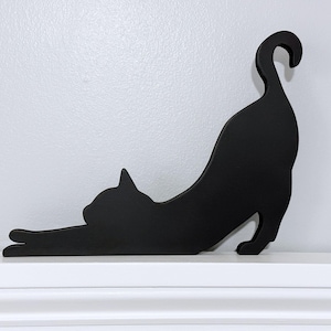 Stretching black cat door topper or shelf sitter