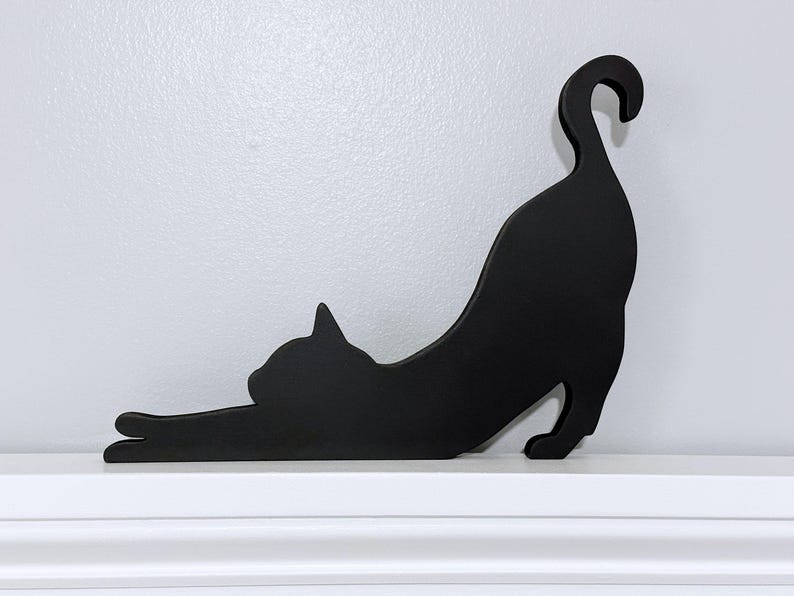 Stretching black cat door topper or shelf sitter