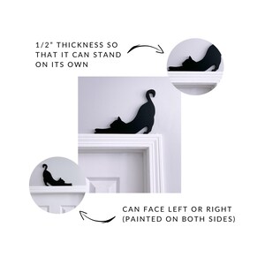 a black cat silhouette on a white door frame, with arrows pointing to the cat's face and indicating that it can stand on its own.