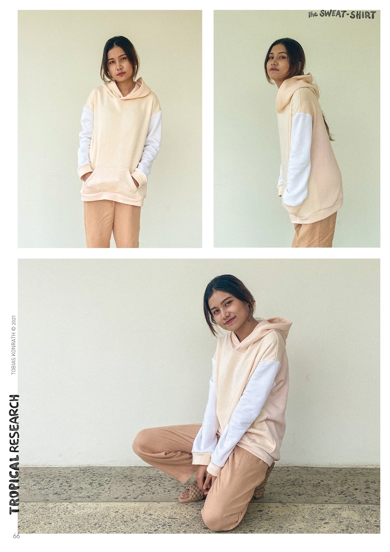 May include: A peach-coloured hoodie with white sleeves and a front pocket, worn with matching peach-coloured trousers. The sweatshirt has a hood. The text "TROPICAL RESEARCH" is visible. The image also includes the text "the SWEAT-SHIRT".