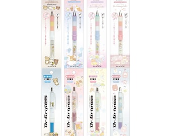 May include: Eight different Dr. Grip mechanical pencils with various character designs. The pencils are all white with a clear plastic barrel and a colourful grip. The characters include Rilakkuma, Sumikko Gurashi, and San-X.