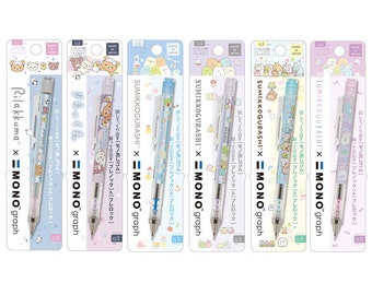 Könnte beinhalten: Fünf verschiedene mechanische Bleistifte mit Sumikko Gurashi und Rilakkuma-Charakteren. Die Stifte sind alle weiß mit durchsichtigen Fässern und haben verschiedene farbige Akzente. Die Stifte sind alle 0,5 mm und haben einen ausziehbaren Radiergummi.