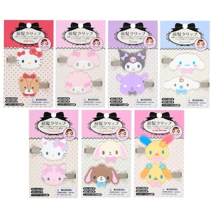 Puede incluir: Una colección de pinzas para el pelo con personajes coloridos, cada una con un diseño diferente. Las pinzas se presentan en tarjetas rosas, rojas, moradas y azules con texto japonés y un lazo negro. Los personajes incluyen Hello Kitty, My Melody, y otros.