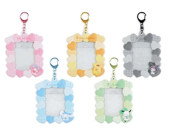 May include: Set of six colorful keychains featuring different Sanrio characters. Each keychain has a heart-shaped frame with a clear photo insert and a metal ring for attaching to keys or bags. The characters include My Melody, Pompompurin, Cinnamoroll, Pochacco, Kuromi, and Badtz-Maru.