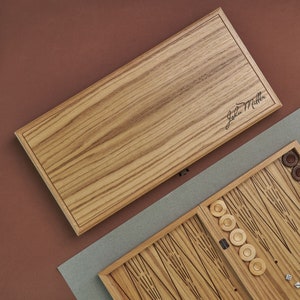 May include: A wooden backgammon set with a personalised wooden lid. The lid is engraved with the name "John Miller".