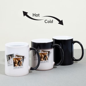 May include: Two white ceramic mugs with black handles and a black ceramic mug with a black handle. The mugs are color-changing mugs that reveal a photo of a couple when hot. The mugs have the text "14.03.2019" and "Adda & Tom" printed on them. The mugs are on a white surface with a black arrow pointing to the right with the word "Cold" and a black arrow pointing to the left with the word "Hot".