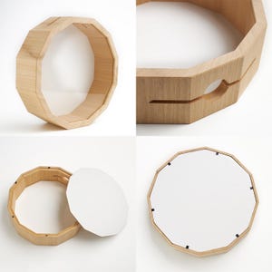 May include: A wooden octagonal mirror with a removable lid. The mirror is made of light wood and has a simple design.