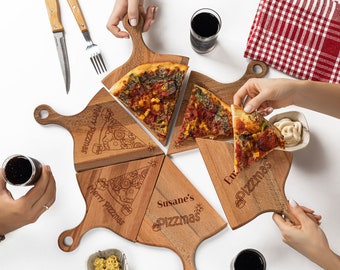 May include: Five wooden pizza serving boards with handles, each with a different design and text. The boards are arranged in a circle, with a slice of pizza on each board. The text on the boards reads "Swizzled Pizza", "Merry Pizzas", "Susane's Pizzas", "Emma's Pizzas", and "Pizza's".