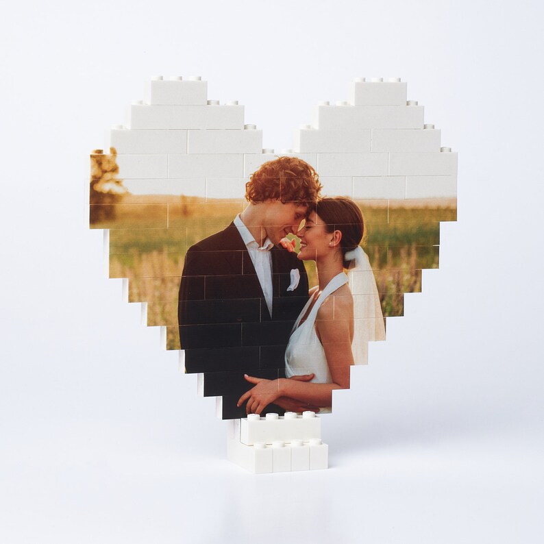 May include: A white LEGO heart-shaped frame with a photo of a couple in love. The couple is dressed in formal attire and is looking at each other.