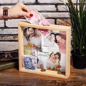 May include: A wooden photo frame with a collage of photos of a couple. The frame has a slot for inserting money and is personalised with the names "Mia Morgan" and the date "12.12.2018".