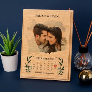 Könnte beinhalten: Eine Holzplakette mit einem Foto eines Paares, einem Kalender für Dezember 2020 und dem Text "FALLON & KEVIN" und "Lifetime of Happiness".