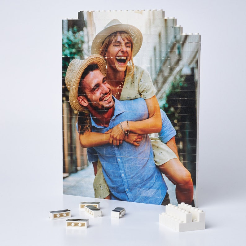 May include: A couple poses for a photo, the woman is holding the man on her back. They are both wearing hats and smiling. The photo is printed on a white background with a grid pattern.