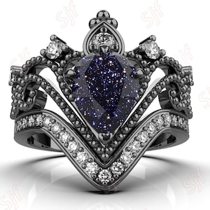 May include: A black crown ring with a blue gemstone and white diamonds. The ring is made of metal and has a detailed design.