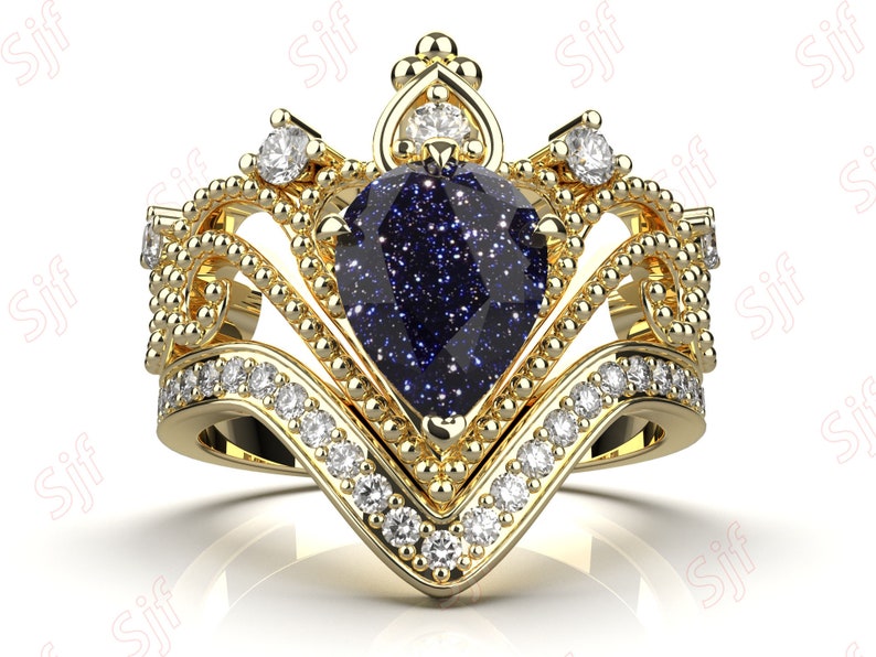 May include: A gold ring with a blue gemstone set in a crown-shaped design. The ring is adorned with smaller diamonds around the gemstone and band.