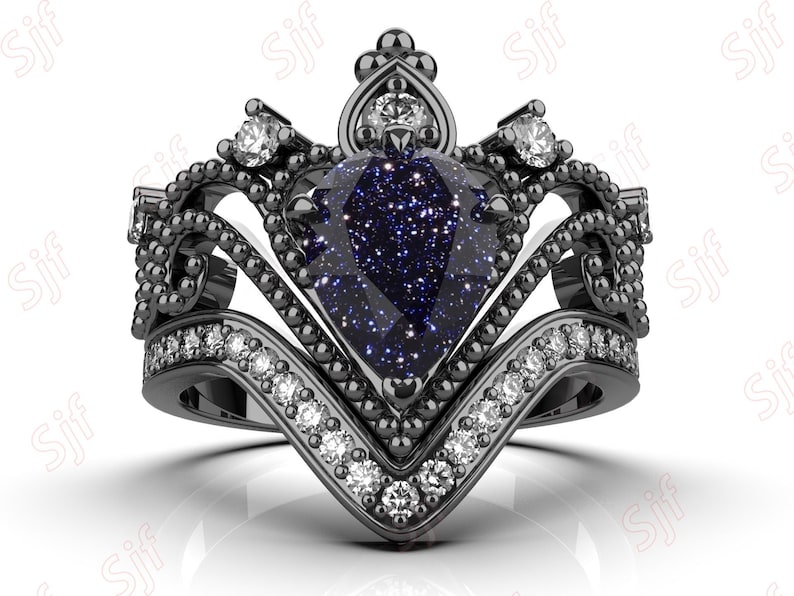 May include: A black crown ring with a blue gemstone and white diamonds. The ring is made of metal and has a detailed design.