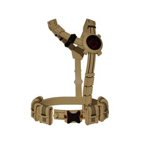 May include: Tan-colored tactical harness with a belt featuring pouches and a central buckle. The harness has a circular element with a red center and black accents. The design includes adjustable straps and multiple attachment points.