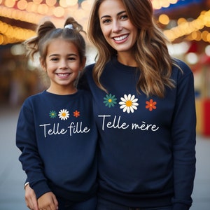 Peut inclure: Deux sweat-shirts bleu marine avec un motif de marguerite et le texte "Telle fille" et "Telle mère".