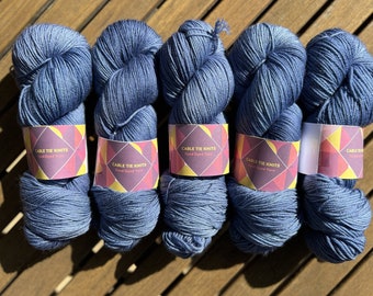 May include: Five skeins of blue hand-dyed yarn with labels that read "Cable Tie Knits Hand Dyed Yarn".