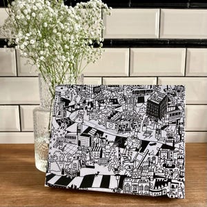 Puede incluir: Ilustraci&oacute;n en blanco y negro de una escena de ciudad con edificios, calles y personas. La ilustraci&oacute;n est&aacute; dibujada en un estilo caprichoso con muchos detalles.