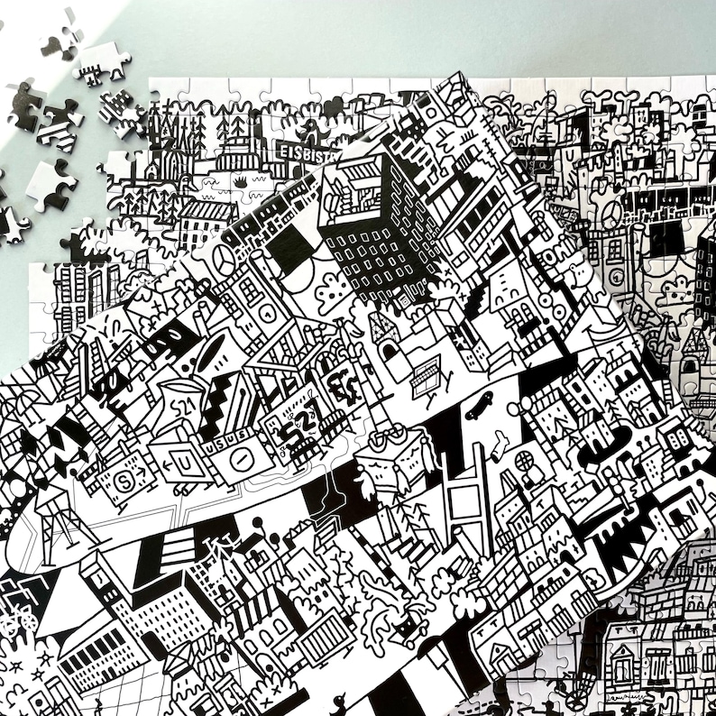 Puede incluir: Rompecabezas en blanco y negro que representa una escena de ciudad con edificios, &aacute;rboles y otros detalles. El rompecabezas est&aacute; parcialmente ensamblado, mostrando el dise&ntilde;o intrincado.