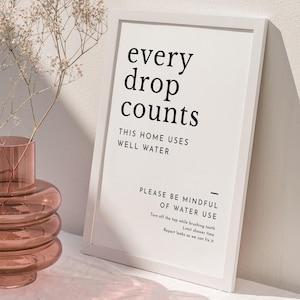 May include: A white framed sign with black text that reads "every drop counts. This home uses well water. Please be mindful of water use. Turn off the tap while brushing teeth. Limit shower time. Report leaks so we can fix it."