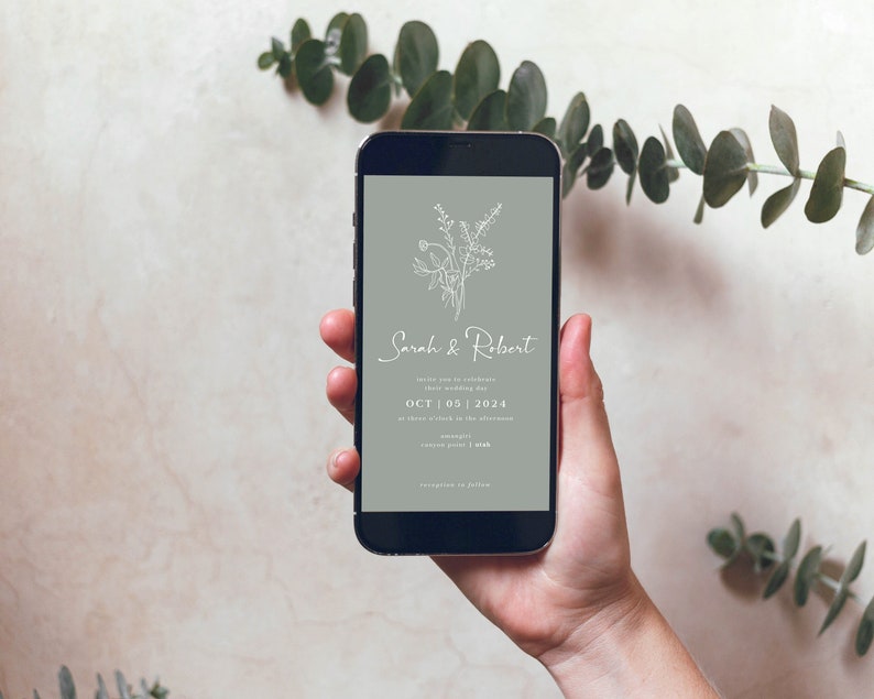May include: A smartphone displaying a wedding invitation with a floral design and the text "Sarah & Robert" and "OCT 05 | 2024".