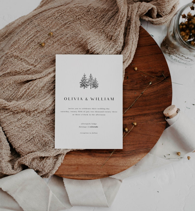 May include: A white wedding invitation with a simple black illustration of two pine trees. The text reads "Olivia & William" and includes the wedding date, time, and location: "Saturday, twenty fifth of July two thousand twenty three at three o'clock in the afternoon, Silverpick Lodge, Durango, Colorado."