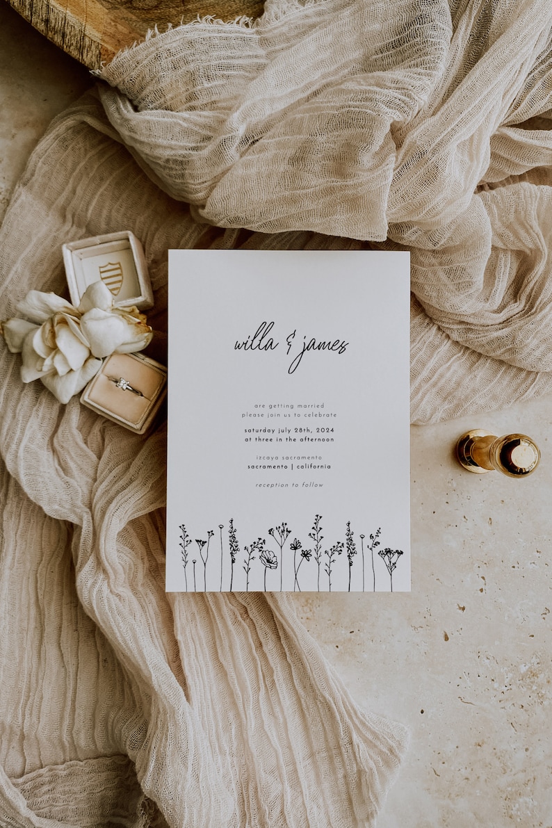 K&ouml;nnte beinhalten: Eine wei&szlig;e Hochzeitseinladung mit schwarzem Text, die die Hochzeit von Willa und James ank&uuml;ndigt. Die Einladung enth&auml;lt Datum, Uhrzeit und Ort der Hochzeitszeremonie und des Empfangs. Am unteren Rand der Einladung befindet sich eine Reihe einfacher schwarzer Strichzeichnungen von Wildblumen.
