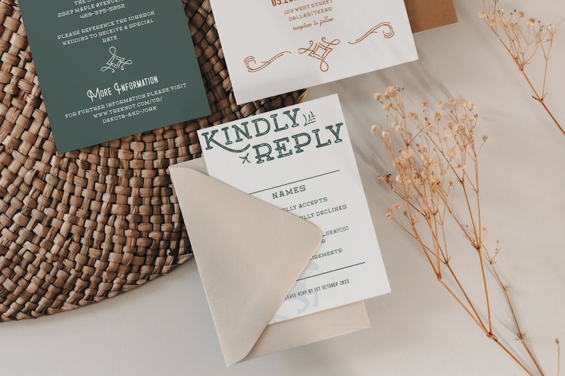 K&ouml;nnte beinhalten: Eine wei&szlig;e RSVP-Karte mit einer gr&uuml;nen und wei&szlig;en &Uuml;berschrift "Kindly Reply". Die Karte hat einen Bereich f&uuml;r Namen und ein Kontrollk&auml;stchen zum Akzeptieren oder Ablehnen der Einladung. Die Karte liegt auf einem beigefarbenen Umschlag.