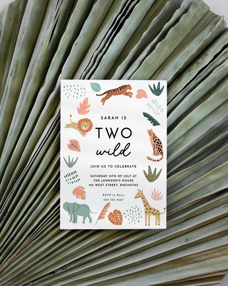 May include: A white invitation card with a jungle theme. The card features a colourful illustration of animals, including a lion, tiger, giraffe, and elephant. The text on the card reads "Sarah is Two Wild" and includes details for a birthday party.