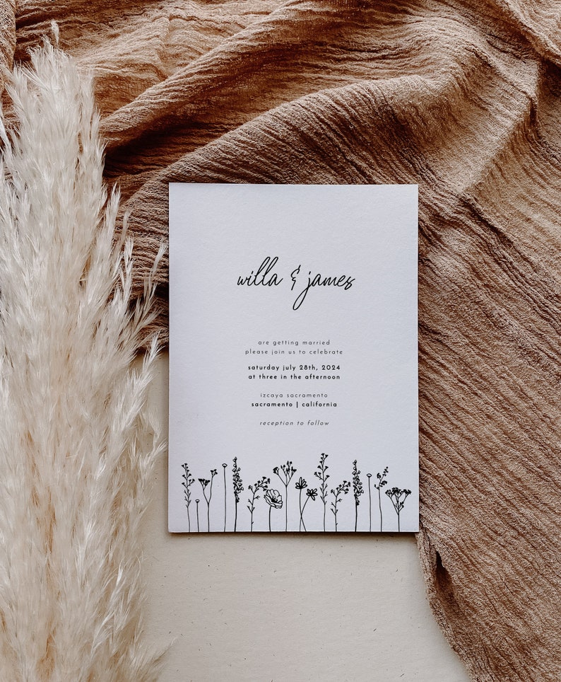 K&ouml;nnte beinhalten: Eine wei&szlig;e Hochzeitseinladung mit schwarzem Text, die die Hochzeit von Willa und James ank&uuml;ndigt. Die Einladung enth&auml;lt Datum, Uhrzeit und Ort der Hochzeitszeremonie und des Empfangs. Am unteren Rand der Einladung befindet sich eine Reihe einfacher schwarzer Strichzeichnungen von Wildblumen.
