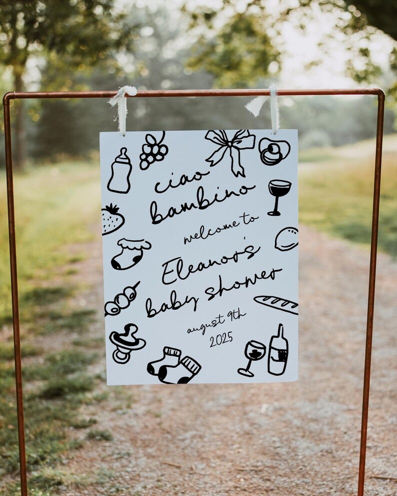 Op de afbeelding: Een wit bord met zwarte doodle-illustraties en de tekst "ciao bambino welcome to Eleanor's baby shower august 9th 2025".