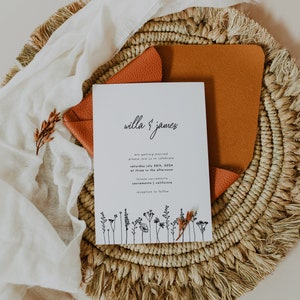 K&ouml;nnte beinhalten: Eine wei&szlig;e Hochzeitseinladungskarte mit schwarzem Text, die die Hochzeit von Willa & James ank&uuml;ndigt. Die Karte zeigt eine einfache Blumenillustration unten und den Text "Samstag, 28. Juli 2024, um 15:00 Uhr Iscaya Sacramento, Sacramento, Kalifornien Empfang folgt."
