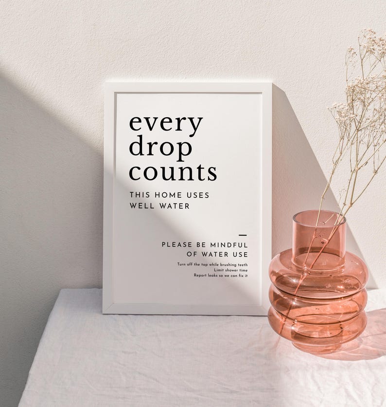 May include: A white framed print with the text "every drop counts" and "This home uses well water". Below the text is a reminder to be mindful of water use with suggestions to turn off the tap while brushing teeth, limit shower time, and report leaks.