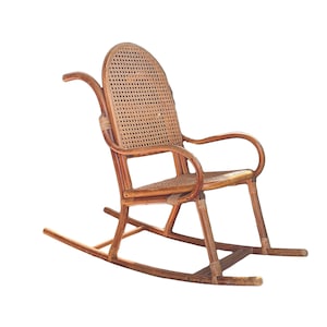 May include: A brown wicker rocking chair with a woven seat and back. The chair has a curved back and arms, and the rockers are made of wood.