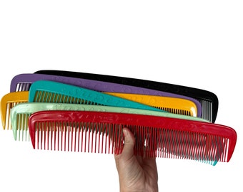 May include: A stack of colorful plastic combs with the word "Super Comb" embossed on each one. The combs are arranged in a rainbow pattern, with the red comb on the bottom and the purple comb on the top.